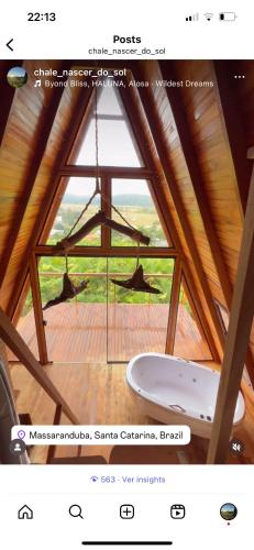 een badkamer met een bad in een kamer met een raam bij Chalé nascer do sol in Massaranduba