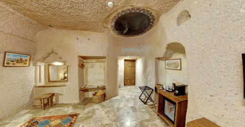 Habitación grande con pared de piedra y techo. en Ages in Cappadocia Premium, en Uchisar