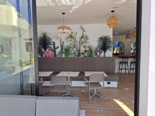 a dining room with a table and chairs and plants at Hotel Diar Meriam in Sousse