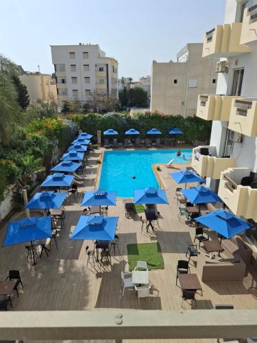 an overhead view of a pool with blue tables and chairs at Hotel Diar Meriam in Sousse