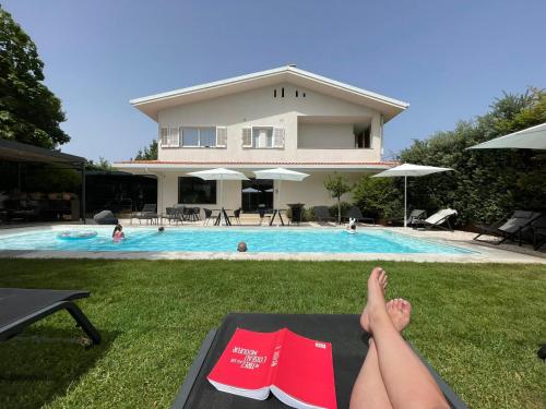 a person laying on a mat in front of a swimming pool at Domìa Boutique Hotel e Cucina in Mondello