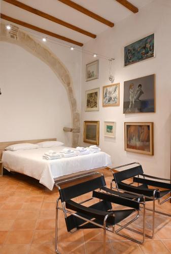 a bedroom with a bed and two chairs at La Corte dell'Annunziata - Casa in centro con giardino in Sulmona