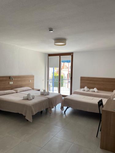 a room with two beds and a large window at Hotel Blason Junior in Peniscola