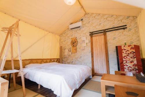 a bedroom with a bed and a desk and a ladder at ウッドデザインパーク瀬戸 in Seto