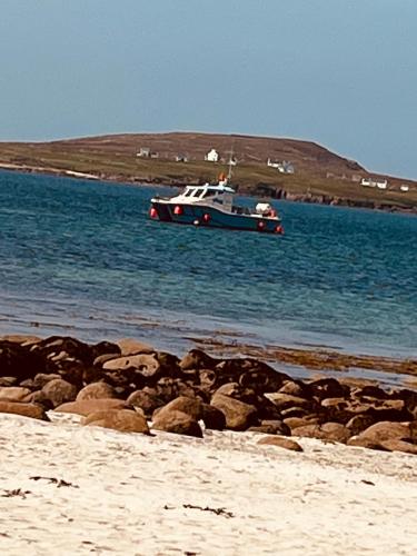 a boat in the water next to a beach at Anchor’s Away in Letterkenny
