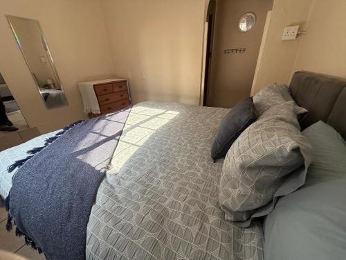 a bedroom with a bed with a blue comforter at Whale's Cove in Amanzimtoti