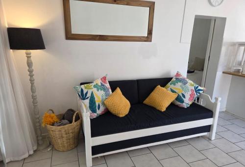 eine schwarz-weiße Couch mit Kissen und einem Spiegel in der Unterkunft The Genet Cottage in Reebok