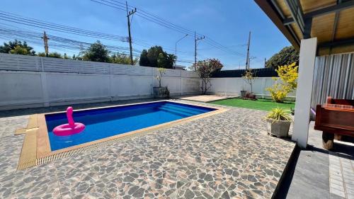 a swimming pool with a pink flamingo in a backyard at บ้านย่าพลูวิลล่าพลาบ้านฉางระยอง in Ban Phala