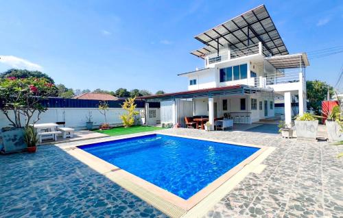 a villa with a swimming pool in front of a house at บ้านย่าพลูวิลล่าพลาบ้านฉางระยอง in Ban Phala