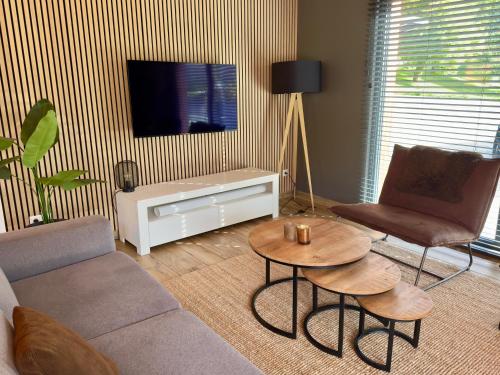 a living room with a couch and a table and a tv at Luxury Chalet Mauthner Alm in Kötschach