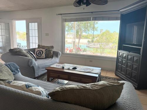 a living room with two couches and a large window at Waterfront 2-BR Home in Providenciales in Providenciales