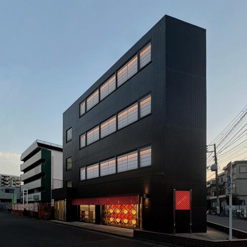 a black building on a city street at OMATSURI BASE Nakanoshimbashi in Tokyo