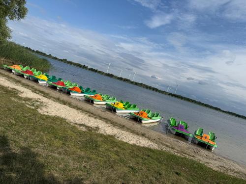 a row of colorful boats sitting on the beach at Domki Przykona in Zimotki