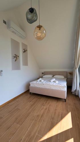 a bedroom with a bed and a wooden floor at 3 Sówki in Krajno Zagórze Drugie