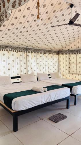 two beds sitting in a room with a ceiling at Unity Sunrise Resort Best Hotel Near Statue of Unity in Kevadia