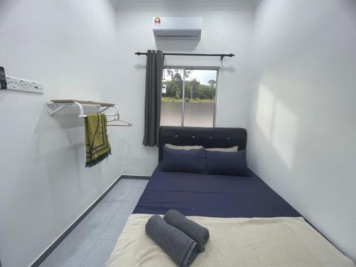 a small room with a bed and a window at Casa de Alyzaa in Kampong Lendu