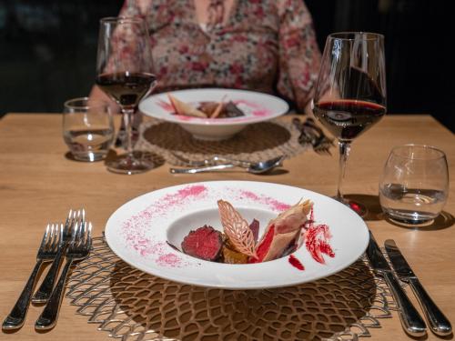 a woman sitting at a table with a plate of food at Hotel Purvita by Oberlechner in Maranza