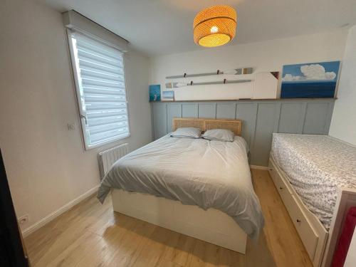 Un dormitorio pequeño con una cama y una ventana. en Cocon d'Aurore, en La Baule