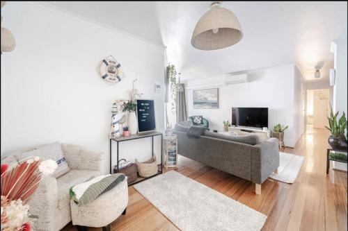 a living room with a couch and a tv at Ultimate Beach Pad in Sydney
