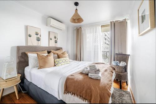 a bedroom with a large bed and a window at Ultimate Beach Pad in Sydney