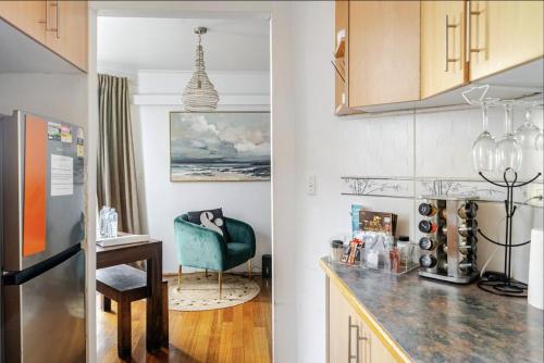 a kitchen with a refrigerator and a table and a chair at Ultimate Beach Pad in Sydney