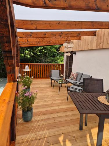 a deck with chairs and tables and a wooden ceiling at Haus Milas in Bad Karlshafen
