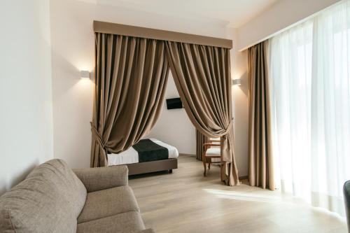 a living room with a couch and a bed and curtains at Grand Hotel la Chiusa di Chietri in Alberobello