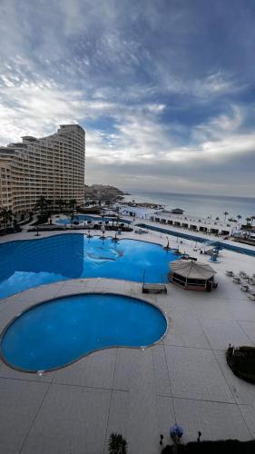 a large pool with blue water in a resort at Apartments Porto sokhnaPyramids family in Ain Sokhna