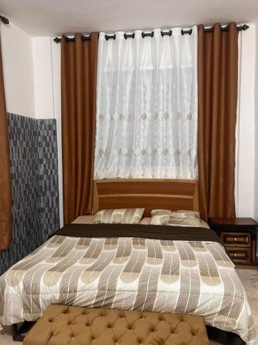 a bed in a bedroom with a window with curtains at المسك للشقق المفروشةدار زمان in Al Mafraq