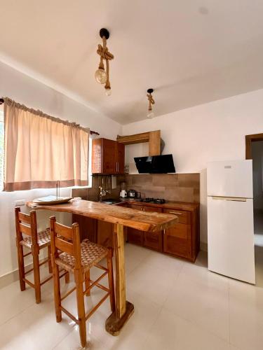a kitchen with a wooden table and a refrigerator at Aparthotel Saoco in Las Terrenas