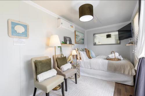 a bedroom with a bed and a chair and a mirror at Tiny Home Beach Serenity! in Sydney
