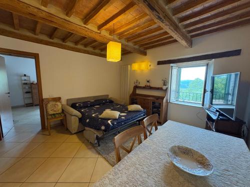 a living room with a table and a bed in it at Foxes house in Monte Fabbri