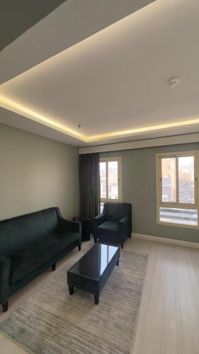 a living room with two couches and a coffee table at مساكن الحجاز الذهبية in Ash Shishah
