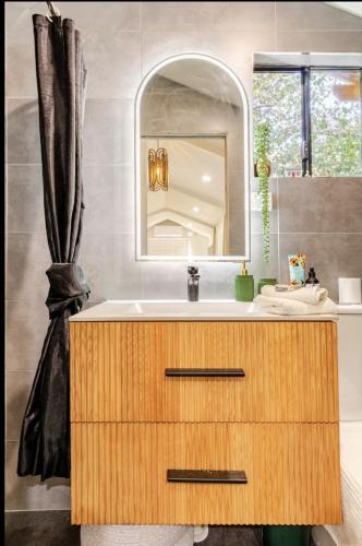 a bathroom with a sink and a mirror at Garden Guesthouse in Sydney