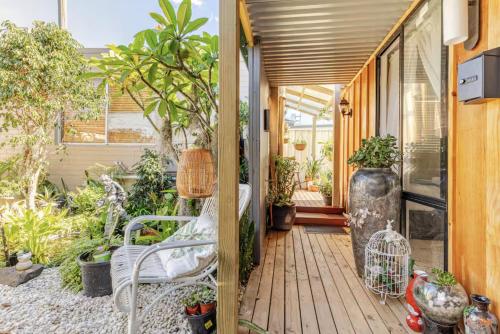 a wooden porch with a bench and plants at Garden Guesthouse in Sydney