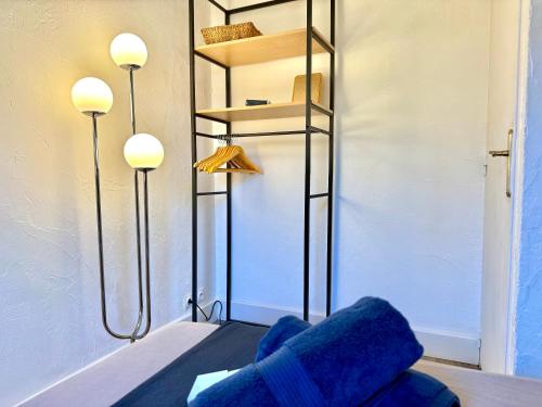 ein Raum mit einem blauen Stuhl und zwei Lichtern in der Unterkunft Refuge reposant - Centre ville - Espace Bureau in Aix-en-Provence