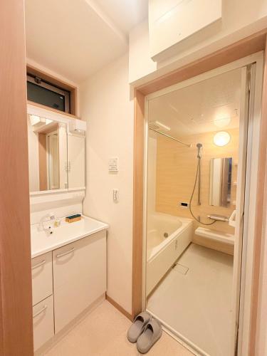 a bathroom with a sink and a bath tub at 池袋銀婚屋 GINKOU's HOUSE -- 2 min train to Ikebukuro Sunshine City in Tokyo