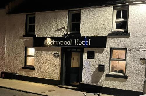 a building with a sign for a local hotel at Lochindaal Hotel in Port Charlotte
