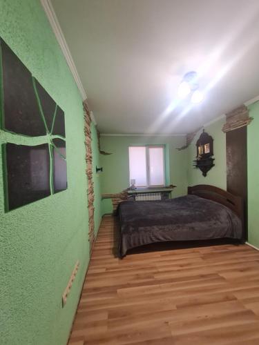 a bedroom with a bed and a green wall at 4 Кімнатні Апартаменти в Центрі, вул Незалежності, 5 in Luts'k