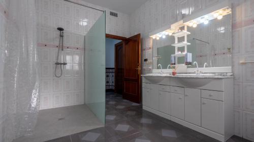 a bathroom with a sink and a shower and a mirror at Los Tatos Alojamiento Rural in Mures