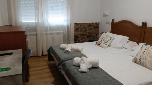 a bedroom with two beds with towels on them at Pensión Atlántico in Muxia