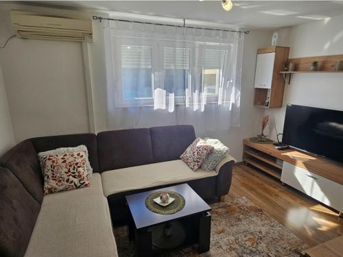 a living room with a couch and a tv at The View in Ploče