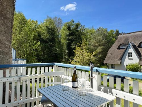 a table with wine bottles and glasses on a deck at Achtern Diek Haus 11 Wohnung 7 "Am Meer" in Müggenburg