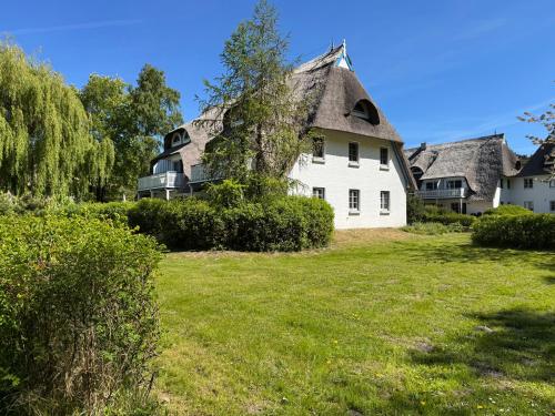 a large white house with a thatched roof at Achtern Diek Haus 11 Wohnung 7 "Am Meer" in Müggenburg