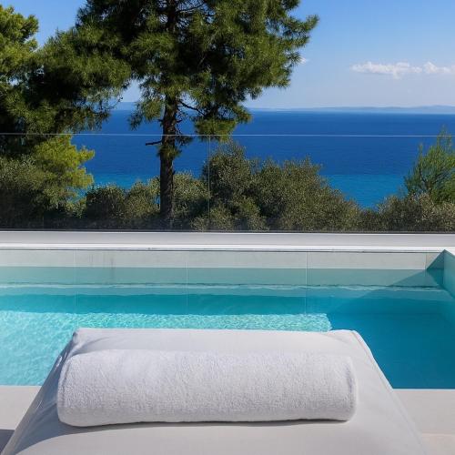 a swimming pool with a view of the ocean at Gloria Luxury Suites in Kallithea Halkidikis