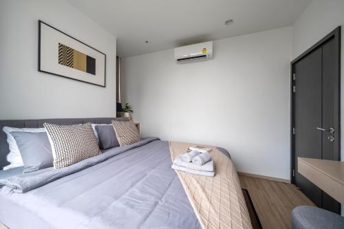a bedroom with a bed in a room with white walls at Vacaystation Edge Central Pattaya in Pattaya Central