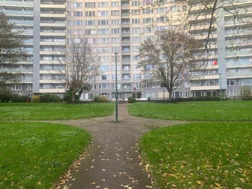 a path in a park with a large building at Appartement 2 chambres à Place Coronmeuse in Herstal