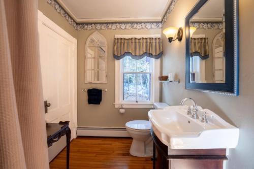 a bathroom with a sink and a toilet and a window at Dominion Hill Country Inn in Bocabec