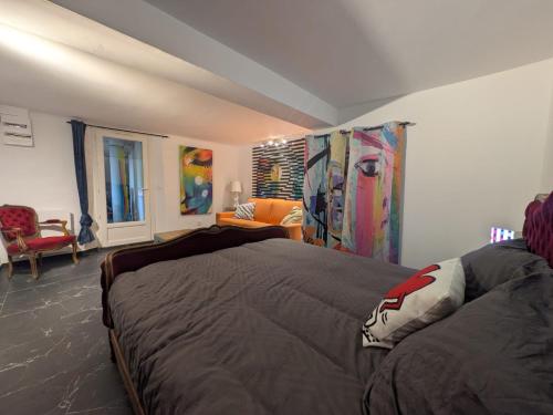 een slaapkamer met een bed en een bank bij Pigments & Paillettes in Draguignan