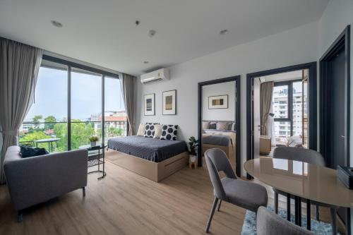 a bedroom with a bed and a table and chairs at Vacaystation Edge Central Pattaya in Pattaya Central